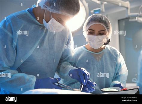 Team Of Professional Doctors Performing Operation In Surgery Room Stock