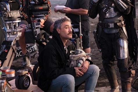 The Mandalorian director Taika Waititi casually holding baby Yoda ...