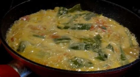 An Omelet Is Being Cooked In A Pan On The Stove