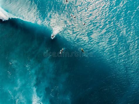 Aerial View Of Surfers In Tropical Blue Ocean With Waves At Bali Top