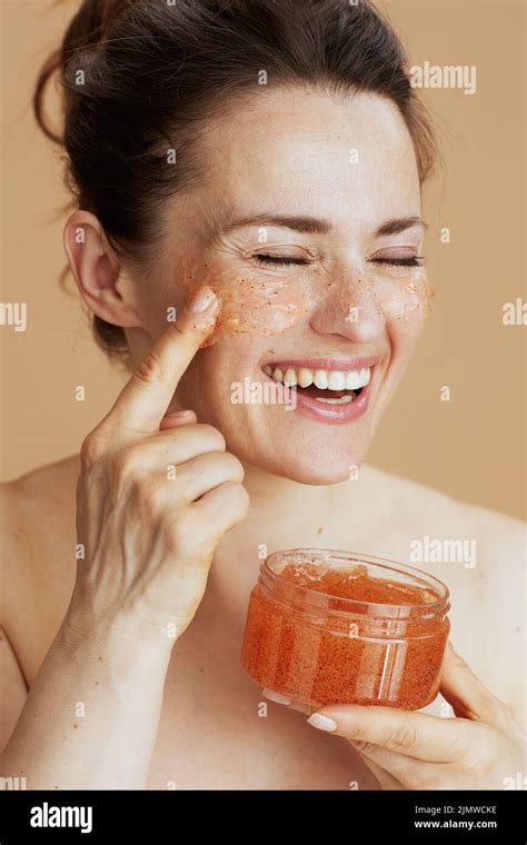 Smiling Modern 40 Years Old Woman With Face Scrub On Beige Background