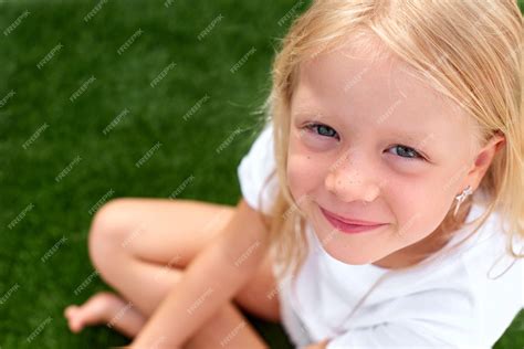 Premium Photo Pretty Blonde Girl White T Shirt Sitting On Green Grass Top View