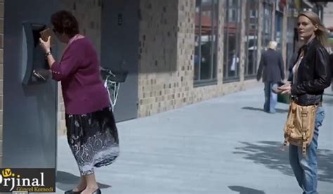 Le soleil semble embêter cette dame au guichet automatique Voyez comment la jolie blonde lui