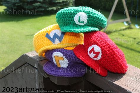 Three Crocheted Hats Sitting On Top Of A Wooden Fence