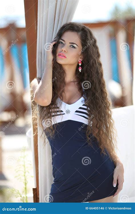 Beautiful Slim Brunette Girl Model With Makeup And Long Wavy Hair Near Beach Bed At The Beach