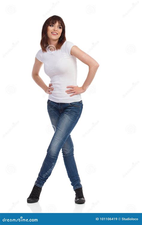 Young Woman Is Standing With Legs Crossed And Looking Away Stock Image