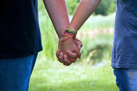 Mãos Adolescentes Da Terra Arrendada Dos Pares Da Idade Amor Do Verão