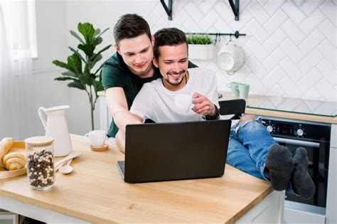 Premium Photo Happy Gay Male Couple Embracing While Using Laptop Having A Good Time Together