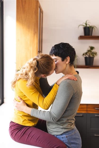 Premium Photo Romantic Biracial Lesbian Couple Embracing And Kissing In Kitchen Copy Space