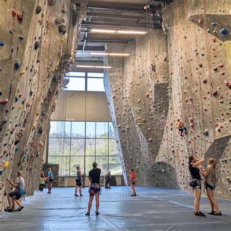 Snapshot Of A Climbing Gym With People Scaling Indoor Rock Walls