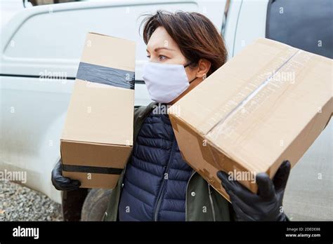 Delivery Service Parcel Carrier With Face Mask And Parcels For Delivery