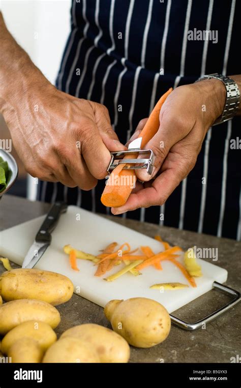 Mature man peeling carrots Stock Photo - Alamy