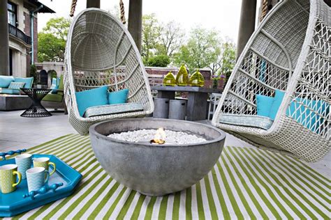 Two Hanging Chairs And A Fire Pit On A Patio