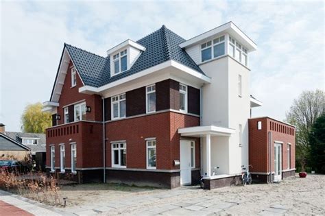 A Red Brick House With White Trim And Windows