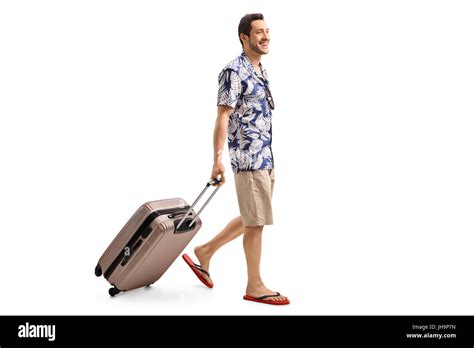 Full Length Profile Shot Of A Tourist Walking And Pulling A Suitcase