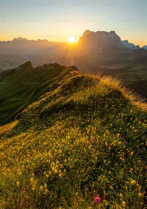 The sun is setting over a grassy hill photo – Outdoors Image on Unsplash