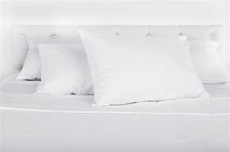 Premium Photo | White pillows on bed in room