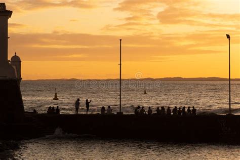 Silhouette Of People At Sunset On The Porto Da Barra Pier Editorial