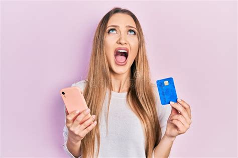 Jeune Fille Blonde Tenant Son Smartphone Et Sa Carte De Crédit Furieuse Et Furieuse Hurlant