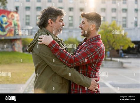 Happy Married Gay Couple Hugging While Looking At Each Other Outdoors