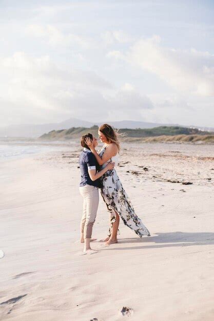 Premium Photo Full Length Of Lesbian Couple Standing On Beach Against Sky