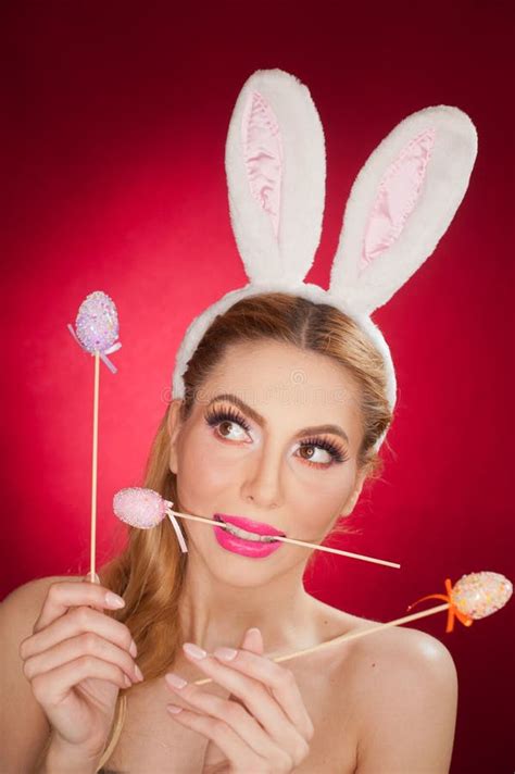 Beautiful Blond Woman As Easter Bunny With Rabbit Ears On Red