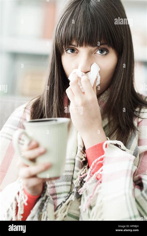 Sick Woman At Home Having Cold And Flu She Is Blowing Her Nose And Having An Hot Drink Stock