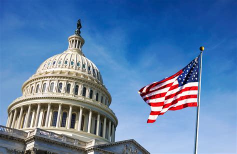American,Flag,Waving,With,The,Capitol,Hill,In,The,Background