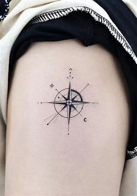 A Black And White Compass Tattoo On The Back Of A Womans Left Thigh