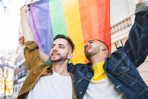 Retrato De Joven Pareja Gay Abrazándose Y Mostrando Su Amor Con La Bandera Del Arco Iris En La