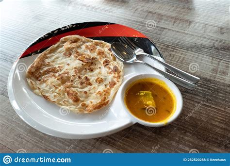 Close Up Of Simple No Frills Roti Canai With Dhal Curry On Wooden Table