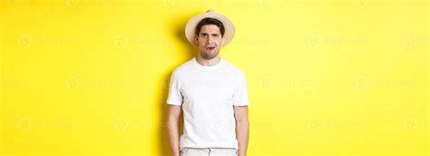Concept of tourism and summer. Confused guy traveller in straw hat