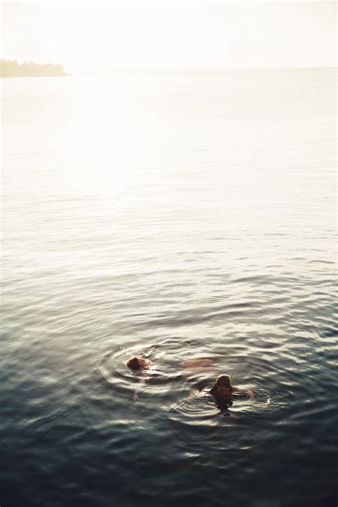 Two People Are Swimming In The Ocean Together