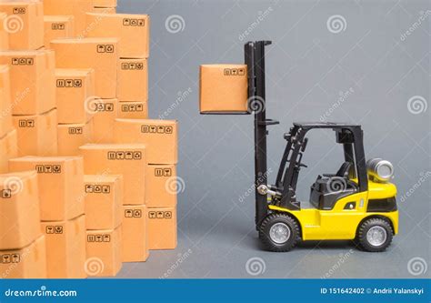 Yellow Forklift Truck Picks Up A Box On A Pile Of Boxes Service