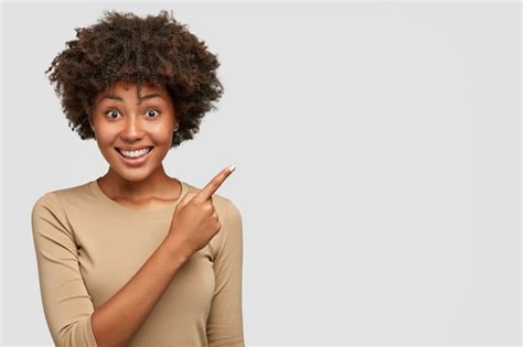 Plan Horizontal Dune Jolie Femme à La Peau Foncée Avec Une Coiffure Afro A Un Large Sourire