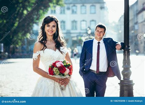 Noiva De Sorriso O Ramalhete Vermelho E Cor De Rosa Do Casamento