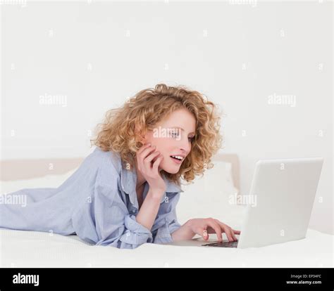 Beautiful Blonde Female Relaxing With Her Laptop While Lying On Her Bed Stock Photo Alamy