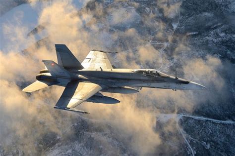 A Fighter Jet Flying Through The Sky Above Clouds