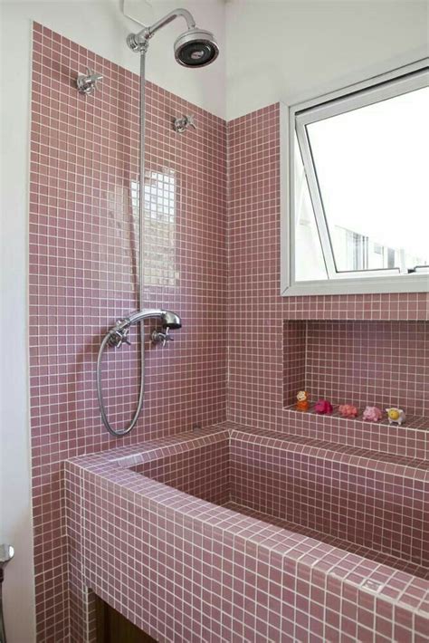 A Bath Room With A Sink And A Shower Head Mounted To The Side Of A Wall