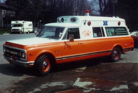 An Orange And White Ambulance Is Parked On The Street