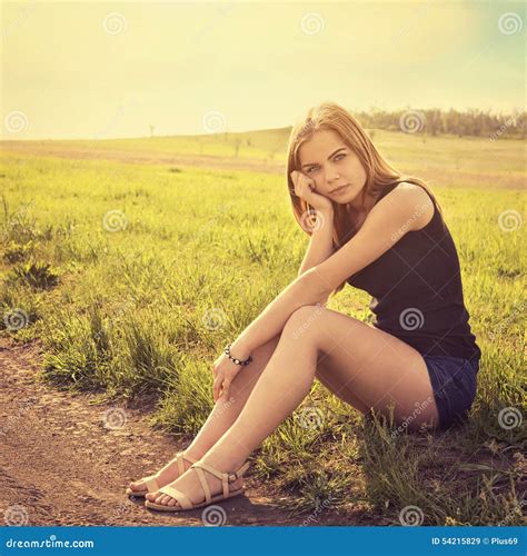 Young Sensual Smiling Blond Woman Sitting On The Grass Outdoors Stock