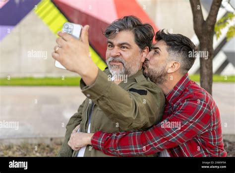 Happy Gay Couple Taking A Break In A Park While Taking A Selfie Stock Photo Alamy