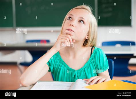 Schoolgirl sitting in a classroom and mulling over a problem Stock ...