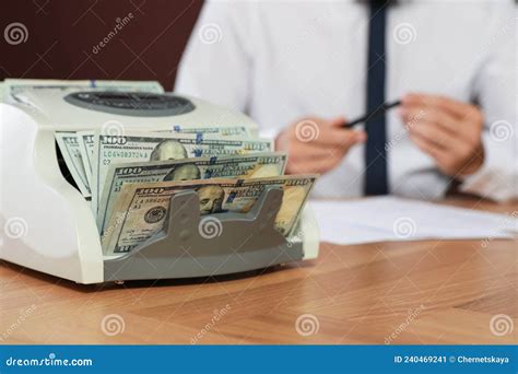 Modern Banknote Counter With Money And Blurred View Of Man Working At