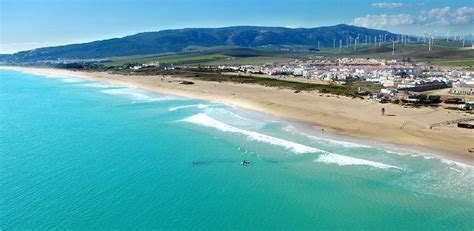 an aerial view of a beach and ocean with houses on the hill in the ...