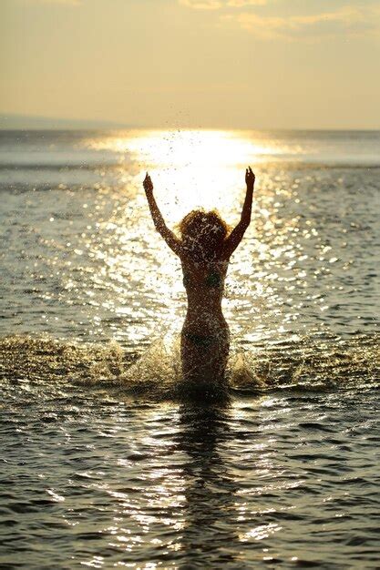 Premium Photo | Woman silhouette in sunset beach