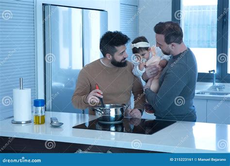 Casal Gay Cozinhando Sua Filha Na Cozinha De Sua Casa Imagem De Stock Imagem De Vidro