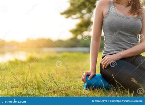 Young Asian Woman Wearing Exercise Suit And Sit On Blue Yoga Mat Or