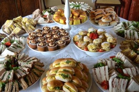 A Table Topped With Lots Of Different Types Of Sandwiches And Cupcakes