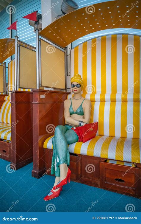 Estatua De Madera De Una Mujer Con Bikini Y Toalla En La Cabeza Sentada En Una Silla De Playa